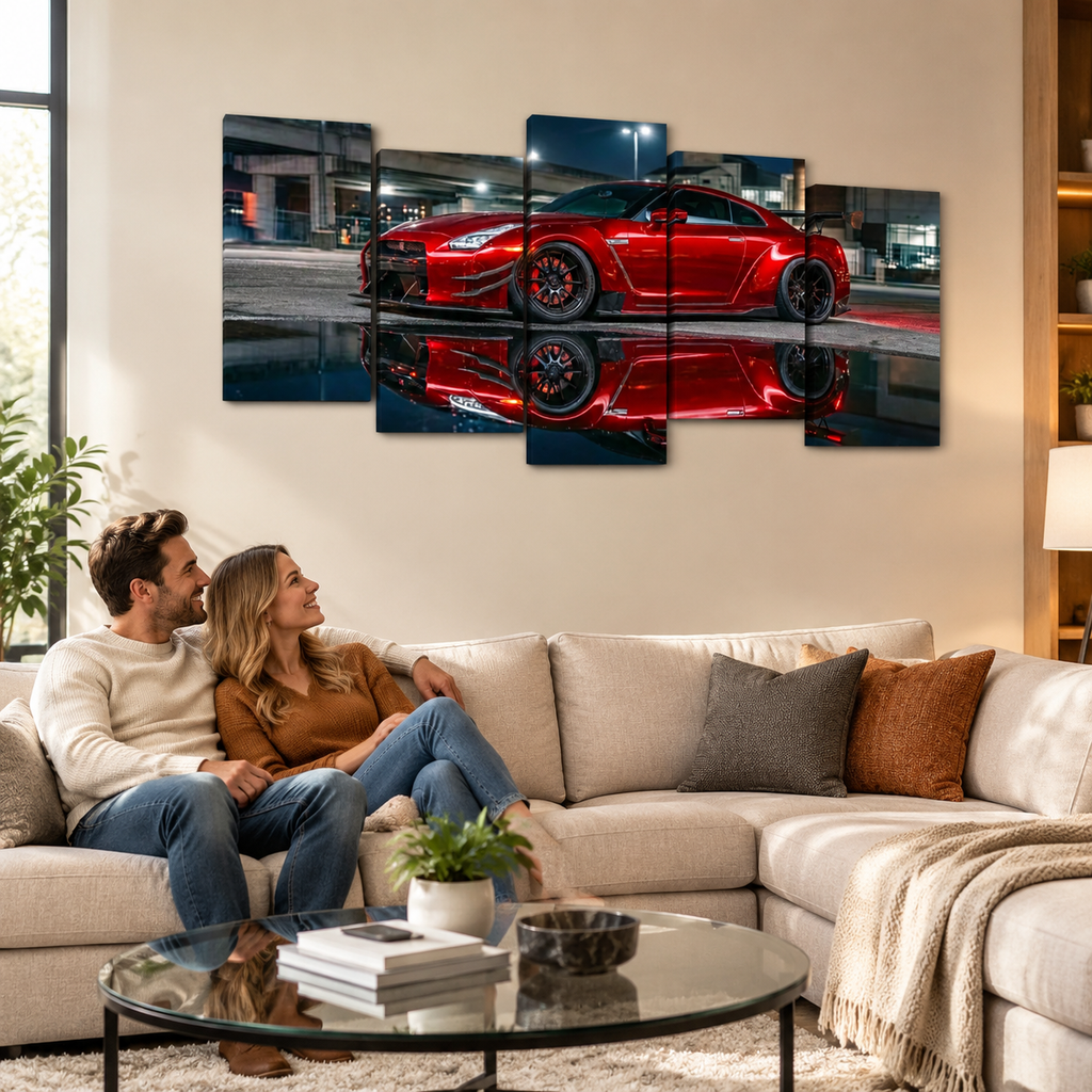 A couple sits on a beige sectional sofa in a modern living room, looking at a five-panel canvas wall art print depicting a red  Nissan GTR R35 sports car reflected on wet pavement at night.