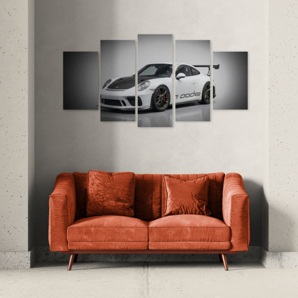 Five-panel wall art of a white porsche 911 gt3 991.2 generation sports car on a gray wall above an orange sofa.