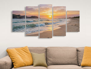 Multiframe wall art of a beach sunset over a sofa with decorative pillows.