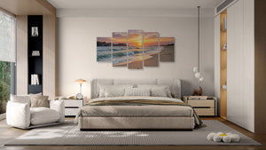 Modern bedroom with a large bed, sofa, and wall art depicting a sunset over water.