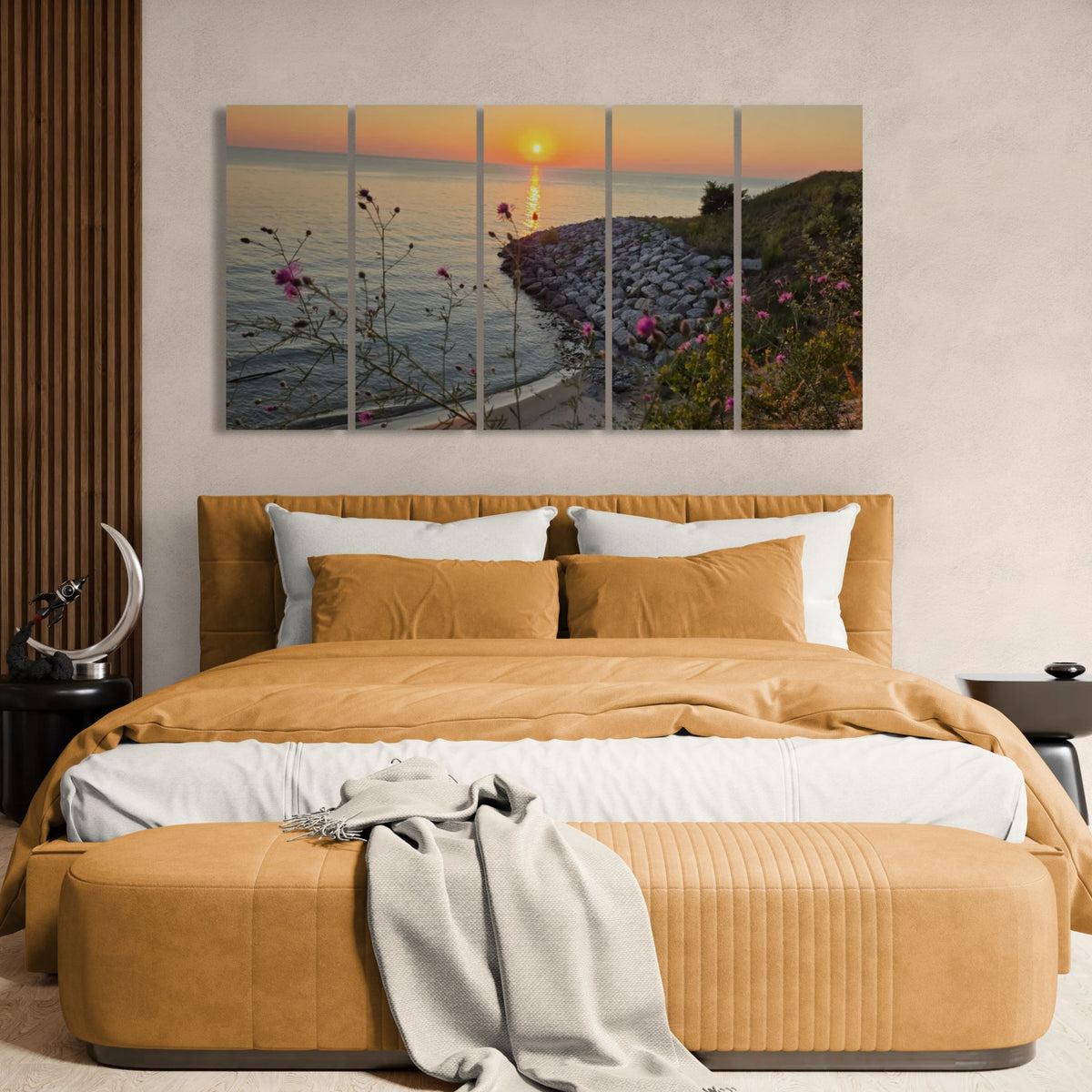 A five-panel canvas wall art print depicting a coastal sunset over the ocean, styled in a modern bedroom above a bed with mustard yellow bedding and a matching bench.