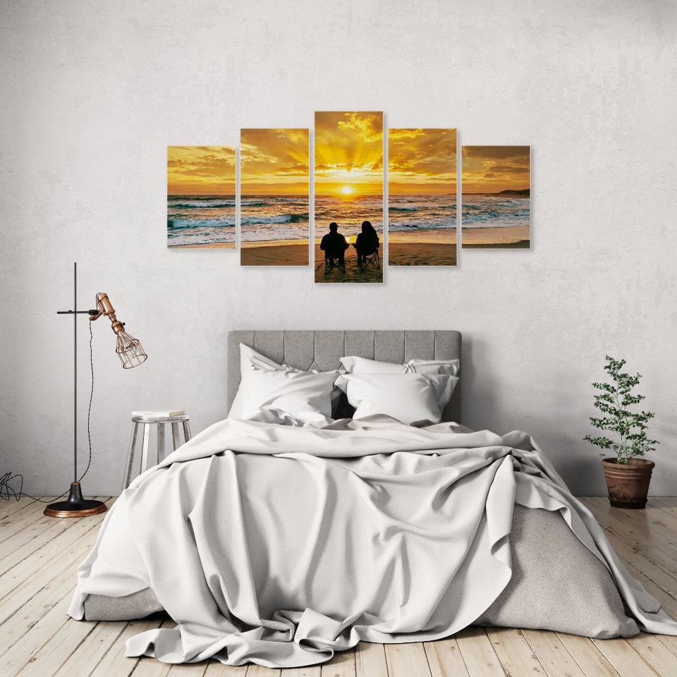 Bedroom with a large wall art piece depicting a sunset over water and two people on a beach.
