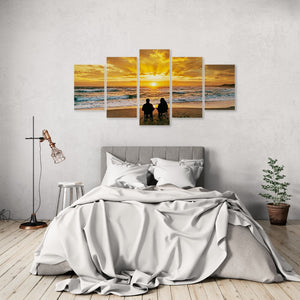 Bedroom with a large wall art piece depicting a sunset over water and two people on a beach.