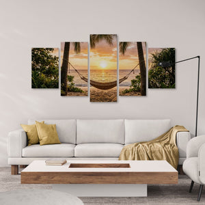 Five-panel wall art of a tropical sunset with a hammock on a white wall above a sofa.