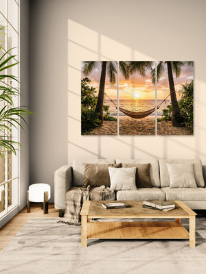 Living room with a large sofa, wooden coffee table, and wall art of a beach scene with a hammock.