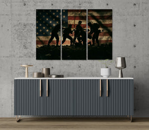 Three-panel wall art with silhouettes of soldiers against an American flag on a gray wall above a modern cabinet.