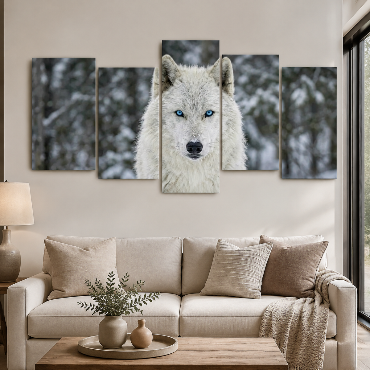 A 5-panel canvas wall art set depicting a close-up portrait of a white wolf with bright blue eyes in a snowy forest, displayed above a beige sofa in a modern living room setting.